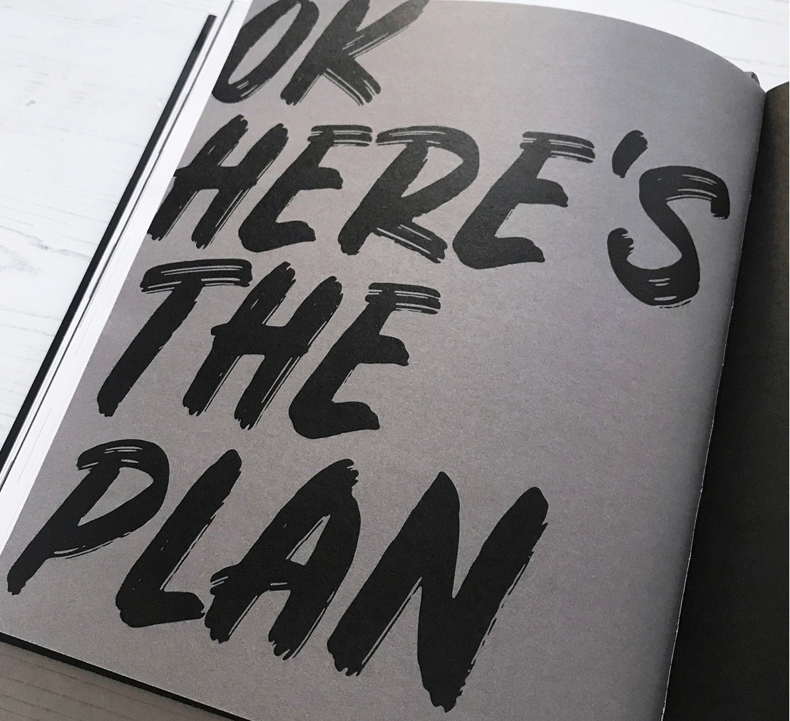 Bold black brush lettering on a planner page reading “OK HERE’S THE PLAN” — a powerful cue to get organised and take action.