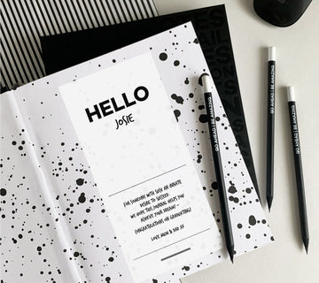 Personalised HELLO TIME planner open to a custom message page reading “HELLO Josie,” paired with black pencils that say “Go Ahead Be Amazing” — the perfect thoughtful gift for goal-getters.