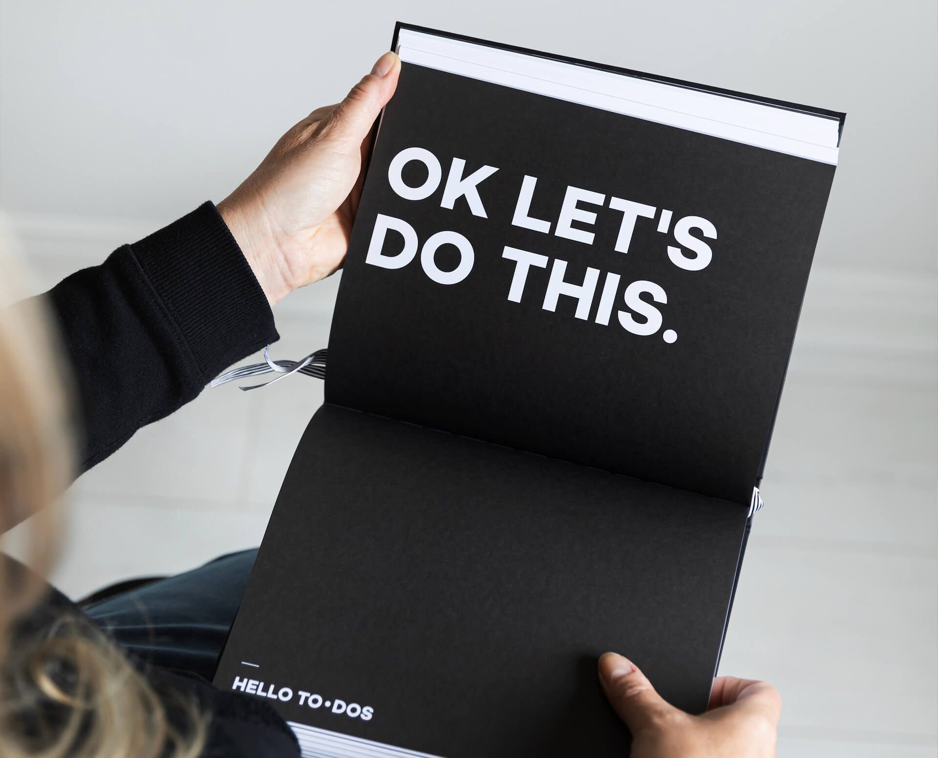 Open HELLO TIME planner showing bold white text reading “OK LET’S DO THIS.” — motivation meets minimal design for getting things done.