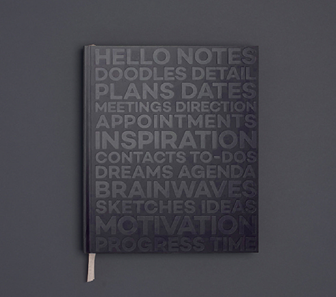 Black HELLO TIME planner with embossed motivational typography on the cover, featuring words like inspiration, plans, and motivation.