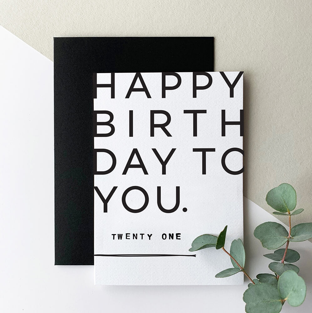 White and black 21st birthday greetings card with bold modern typography and black envelope.