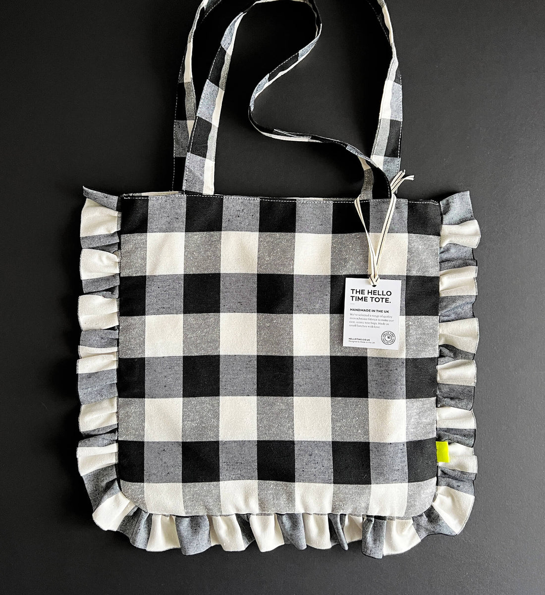 Black and white gingham ruffle tote bag with handles and product tag