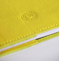 Close-up of a yellow leather notebook with HELLO TIME logo on a white background