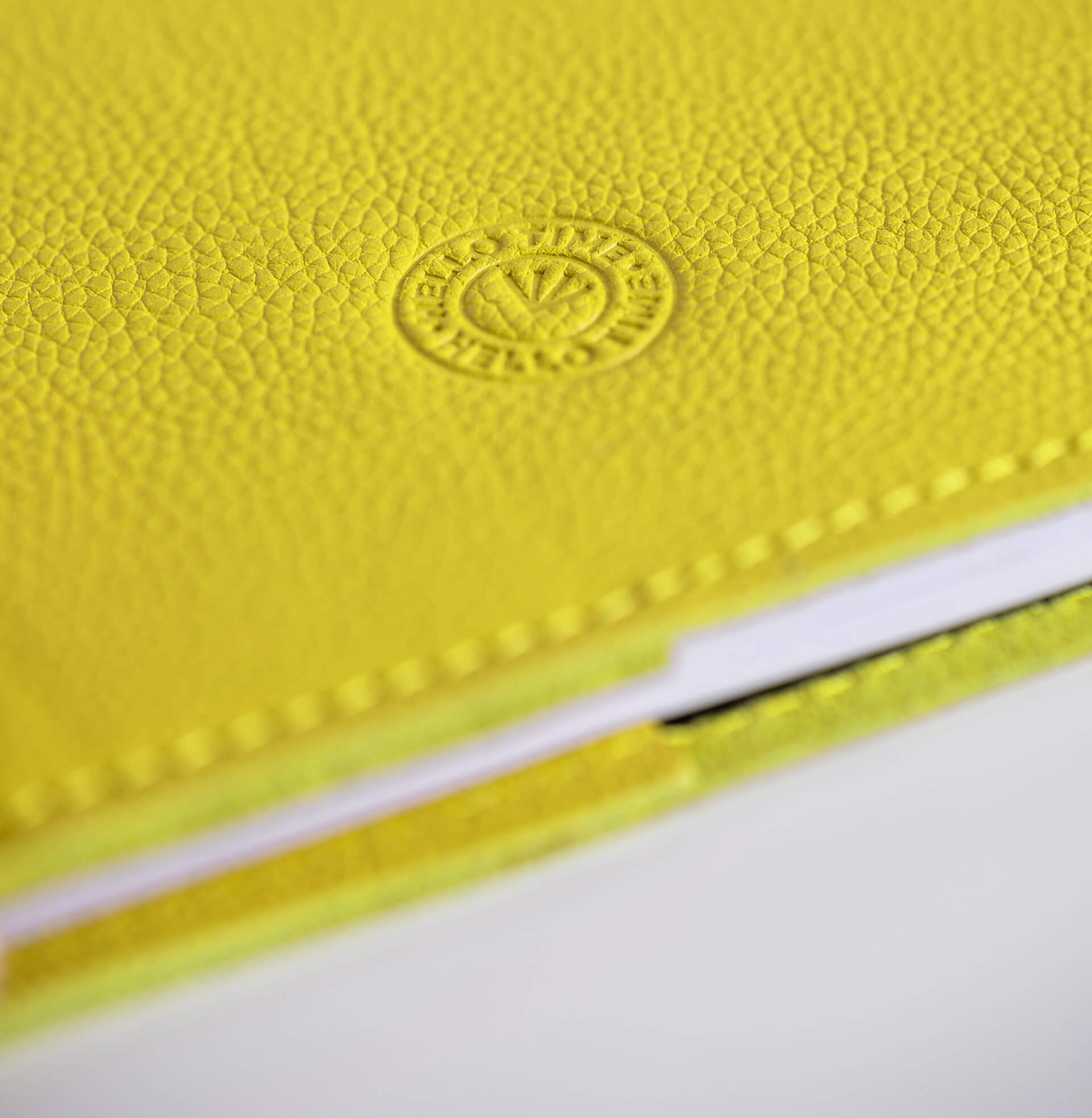 Close-up of a yellow leather notebook with HELLO TIME logo on a white background