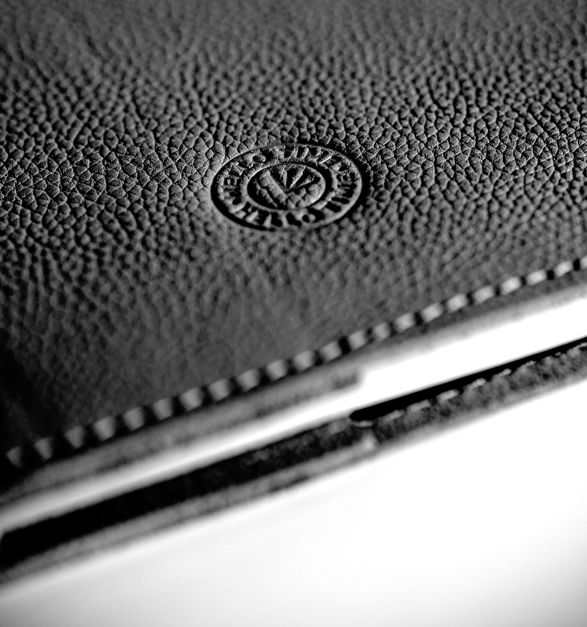 Close-up of a black leather notebook cover with HELLO TIME logo on a white background