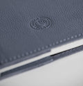 Close-up of a mauve leather notebook with HELLO TIME logo on a white background