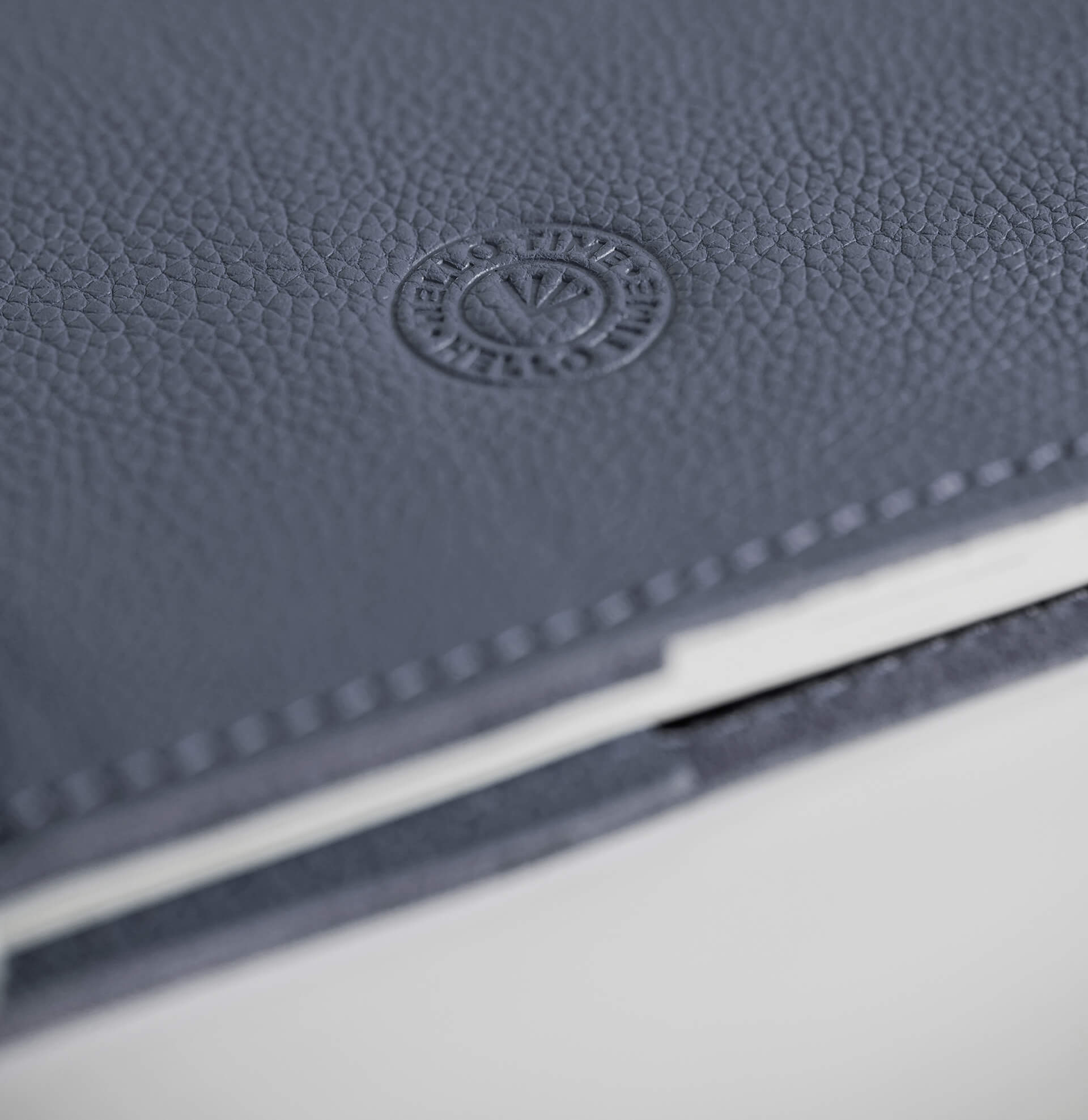 Close-up of a mauve leather notebook with HELLO TIME logo on a white background