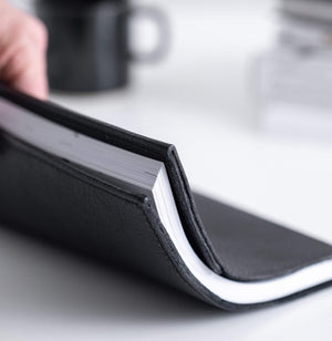HELLO TIME black leather notebook cover shown flexed open with inner pages visible
