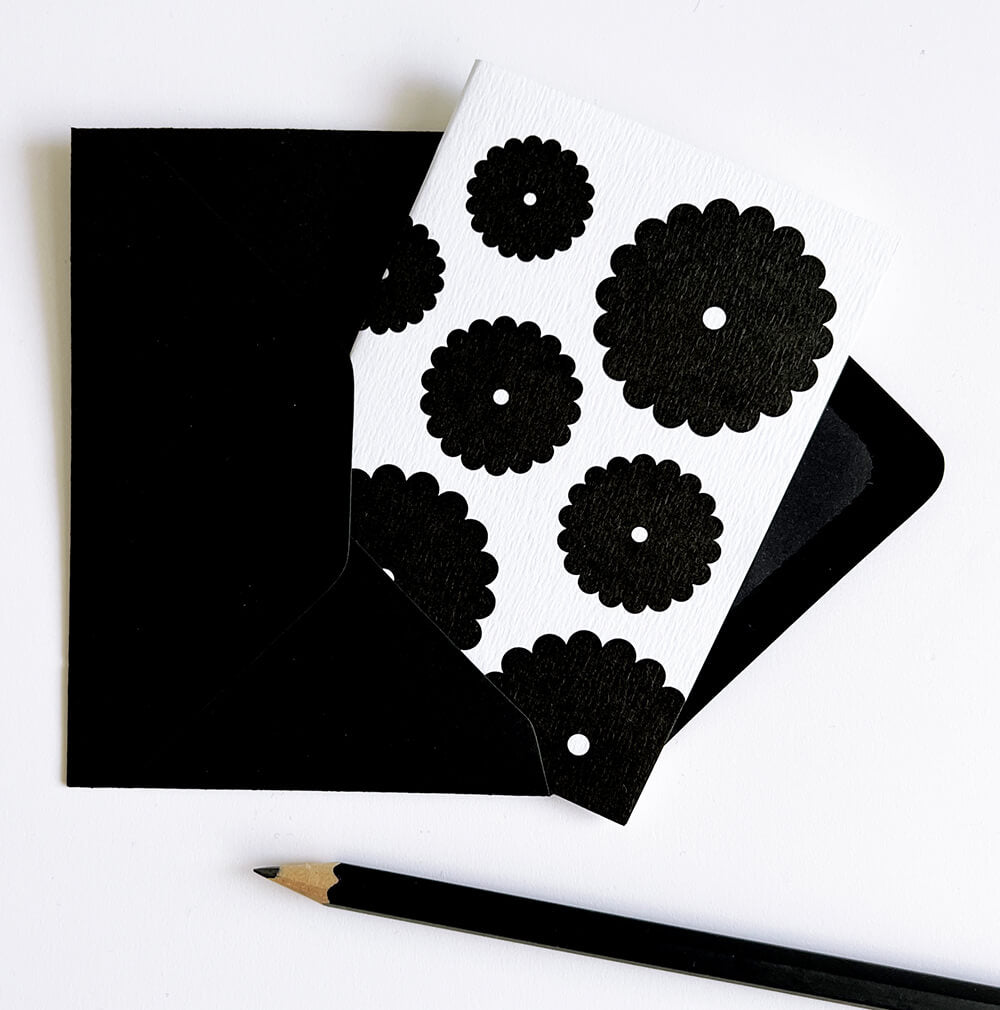 Monochrome card featuring multiple bold black flowers on white stock, shown with matching envelope.