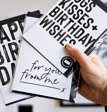 Hand holding monochrome birthday card with handwritten text “for you from me,” packaged with black envelope.