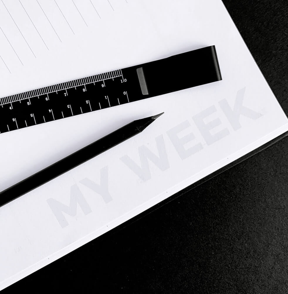 Black HELLO TIME ruler clip and pencil on white weekly planner page with bold MY WEEK heading