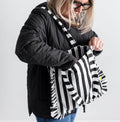 Woman in black coat reaching into black and white striped HELLO TIME tote bag with ruffle edges
