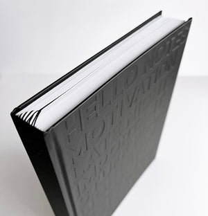 HELLO TIME black planner with embossed motivational words on cover shown from top angle to highlight spine, page edges and ribbon markers