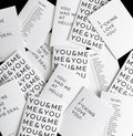 Flat lay of multiple monochrome typographic cards with bold black text messages on white card.