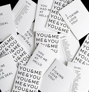 Flat lay of multiple monochrome typographic cards with bold black text messages on white card.