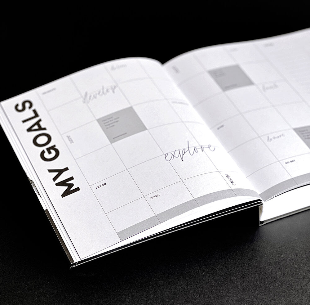 Open HELLO TIME planner showing My Goals section with grid layout on black background