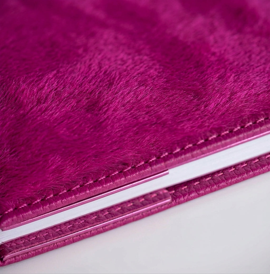 Close-up of magenta hair on hide HELLO TIME notebook cover texture.