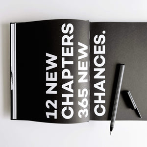 Open black HELLO TIME planner spread with white 