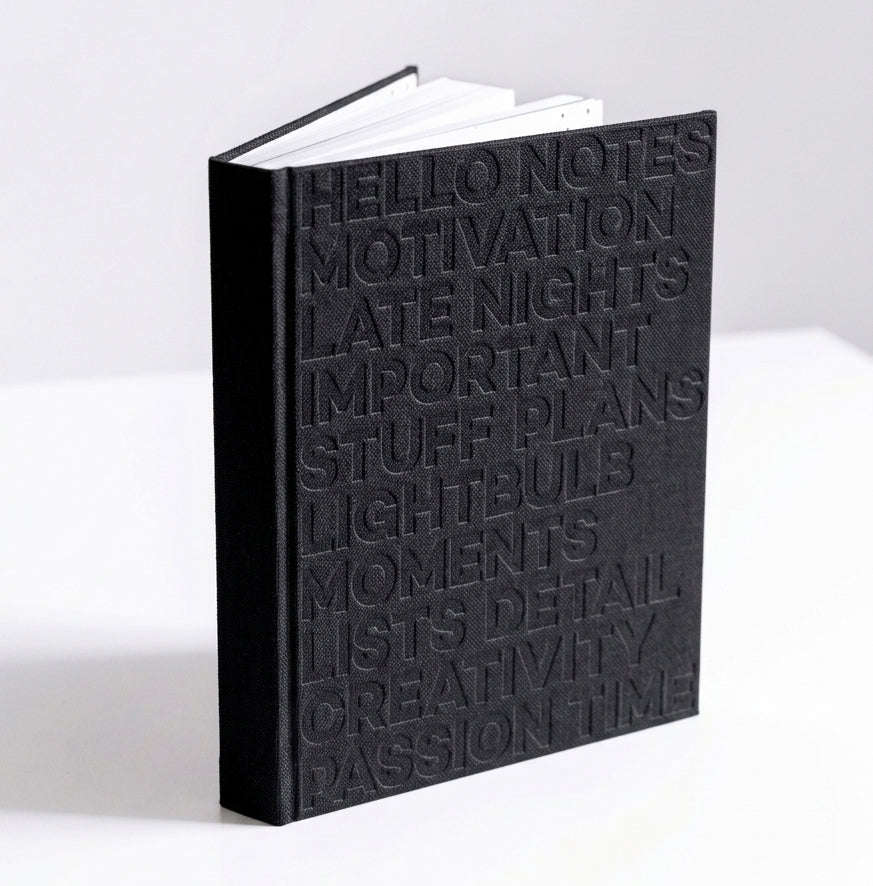 Black HELLO TIME planner standing upright, showing embossed cover text on white background.