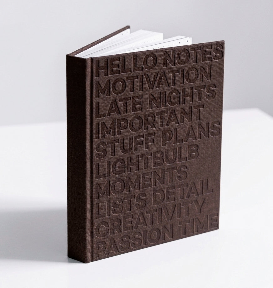 Brown HELLO TIME planner standing upright, showing embossed cover text on white background.