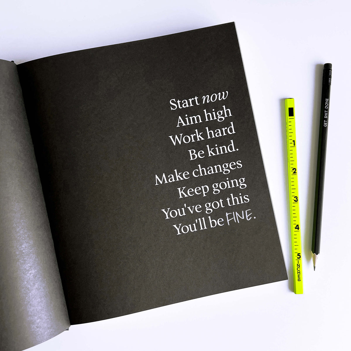 Open black HELLO TIME planner page with white motivational quote text, yellow ruler and "Get shit done" pencil beside it.