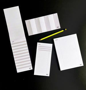 Collection of HELLO TIME to-do list and planner desk pads with neon pencil on black background