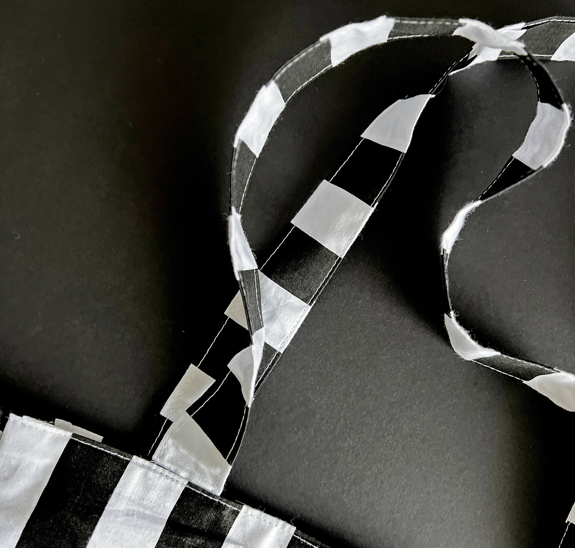 Detail of monochrome striped fabric handles on the HELLO TIME tote bag