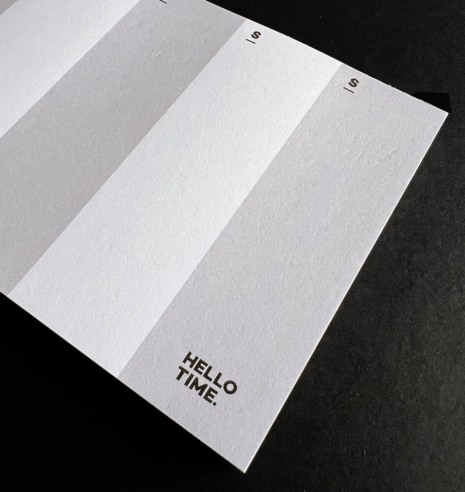 Close-up of HELLO TIME DL-sized weekly pad showing Sunday column and logo on textured white paper.
