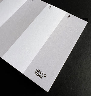 Close-up of HELLO TIME DL-sized weekly pad showing Sunday column and logo on textured white paper.
