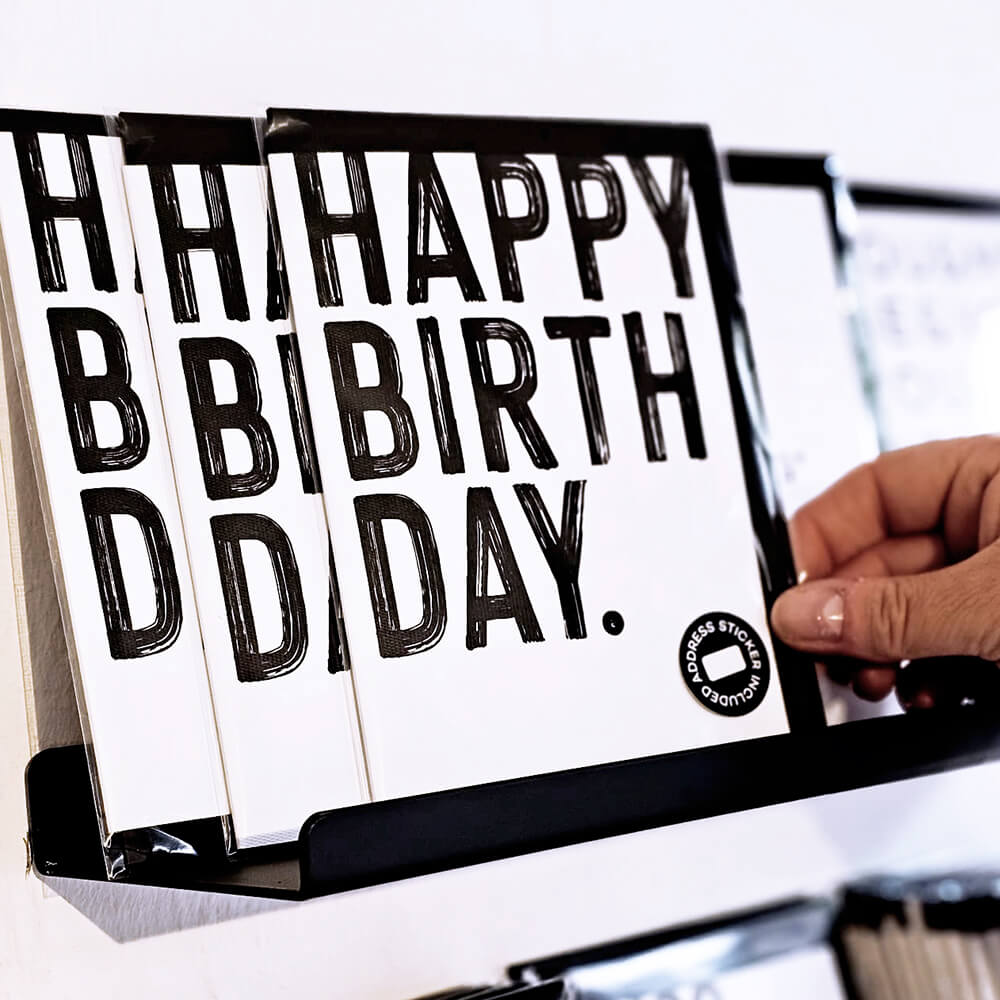 Bold monochrome Happy Birthday greetings card shown in display rack