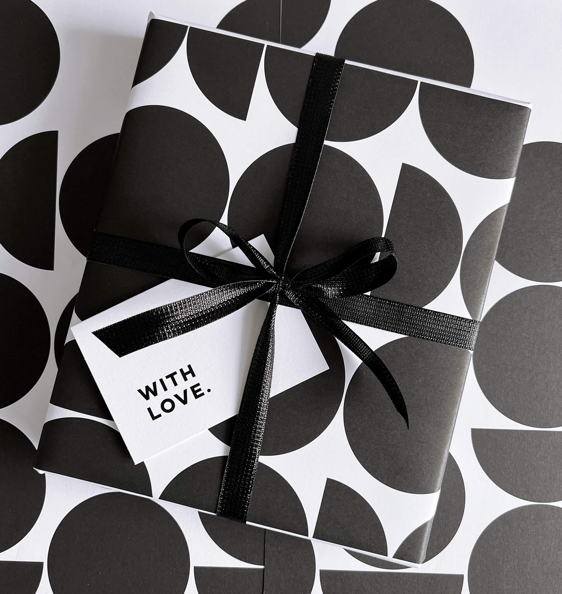 Black and white geometric gift wrap design with black sparkle ribbon and 'with love' gift card.