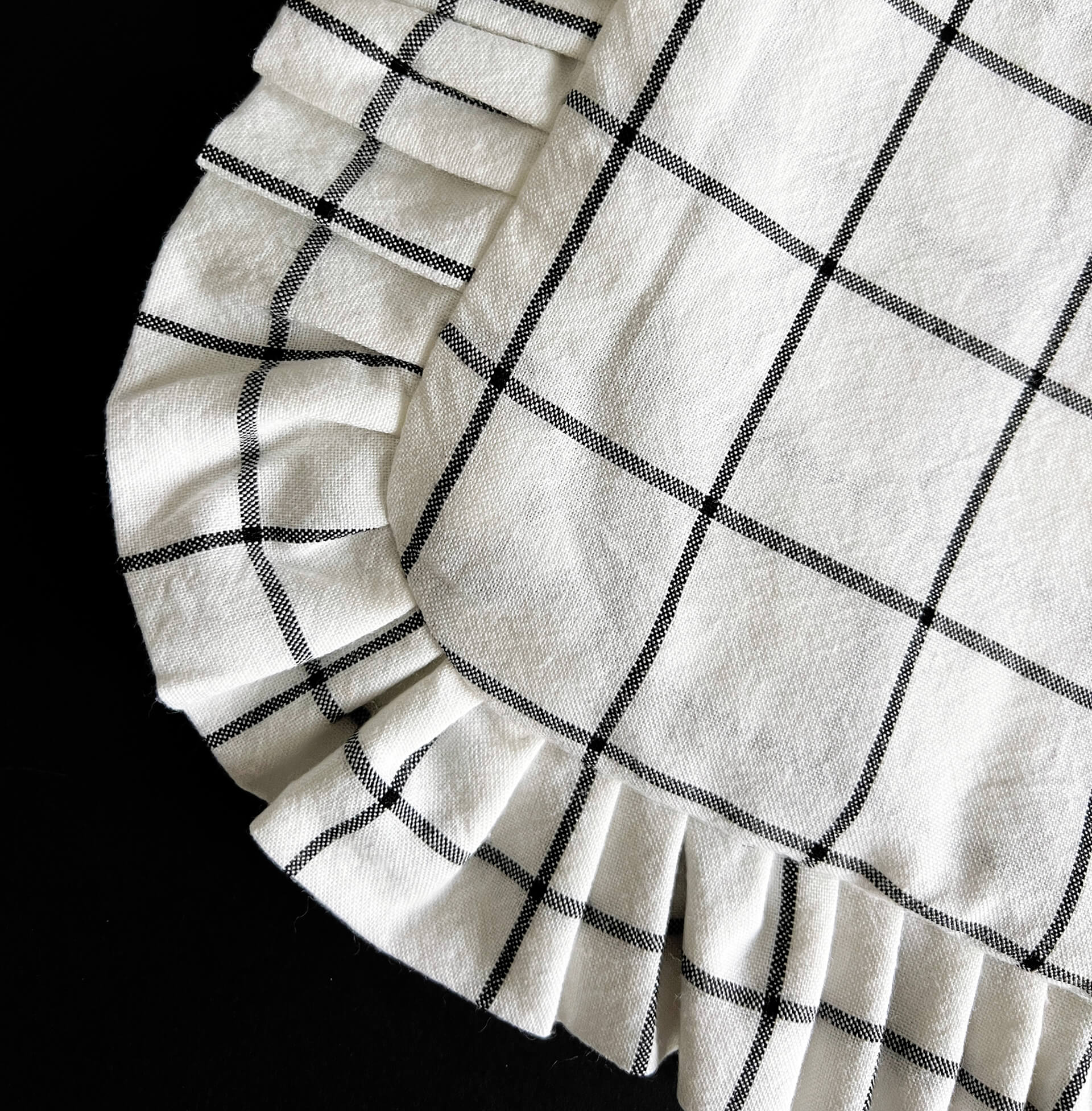 Close-up of ruffle corner of grid tote bag showing stitched check lines