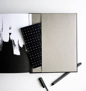 Open planner showing stone-coloured pocket with black date stickers and striped fineliner pen