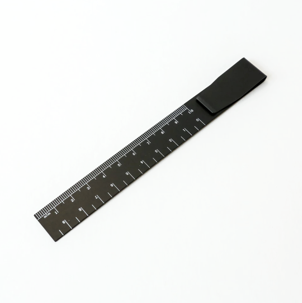 Black metal ruler bookmark with clip, marked with centimetre scale.