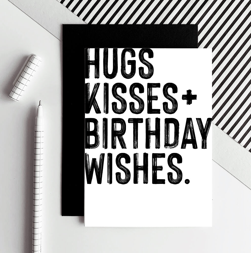 White birthday card with bold black Hugs Kisses Birthday Wishes text and black envelope