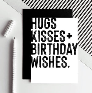 White birthday card with bold black Hugs Kisses Birthday Wishes text and black envelope