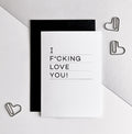 White anniversary card with bold text saying “I f*cking love you” in black, paired with black envelope