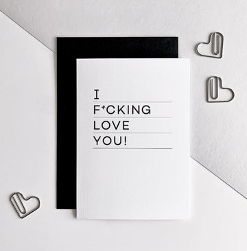 White anniversary card with bold text saying “I f*cking love you” in black, paired with black envelope