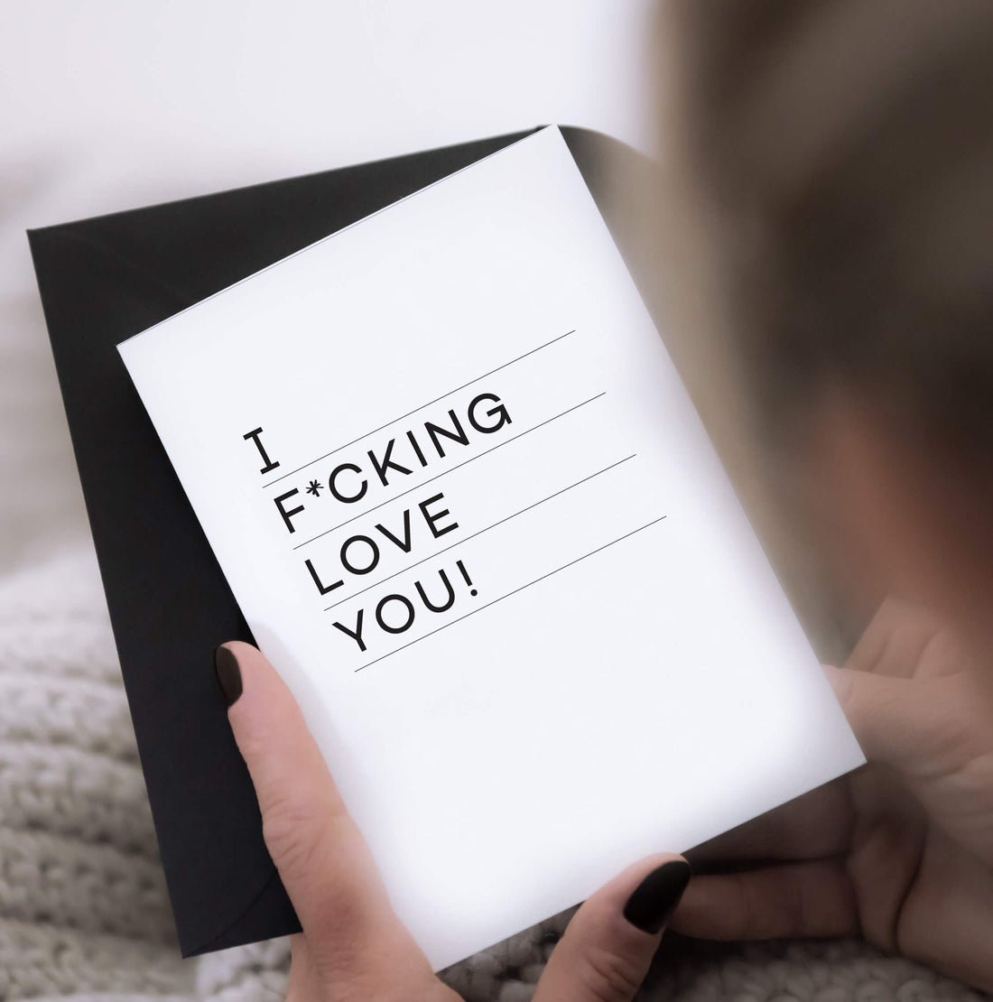 White anniversary card with bold text saying “I f*cking love you” in black, paired with black envelope