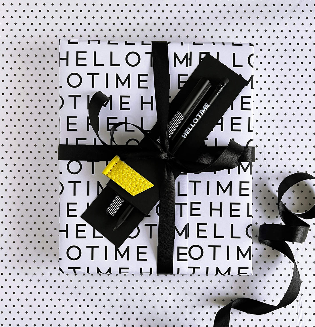 HELLO TIME Life Planning Kit flatlay with black notebook, date stickers, yellow leather page marker, pencil and fineliner