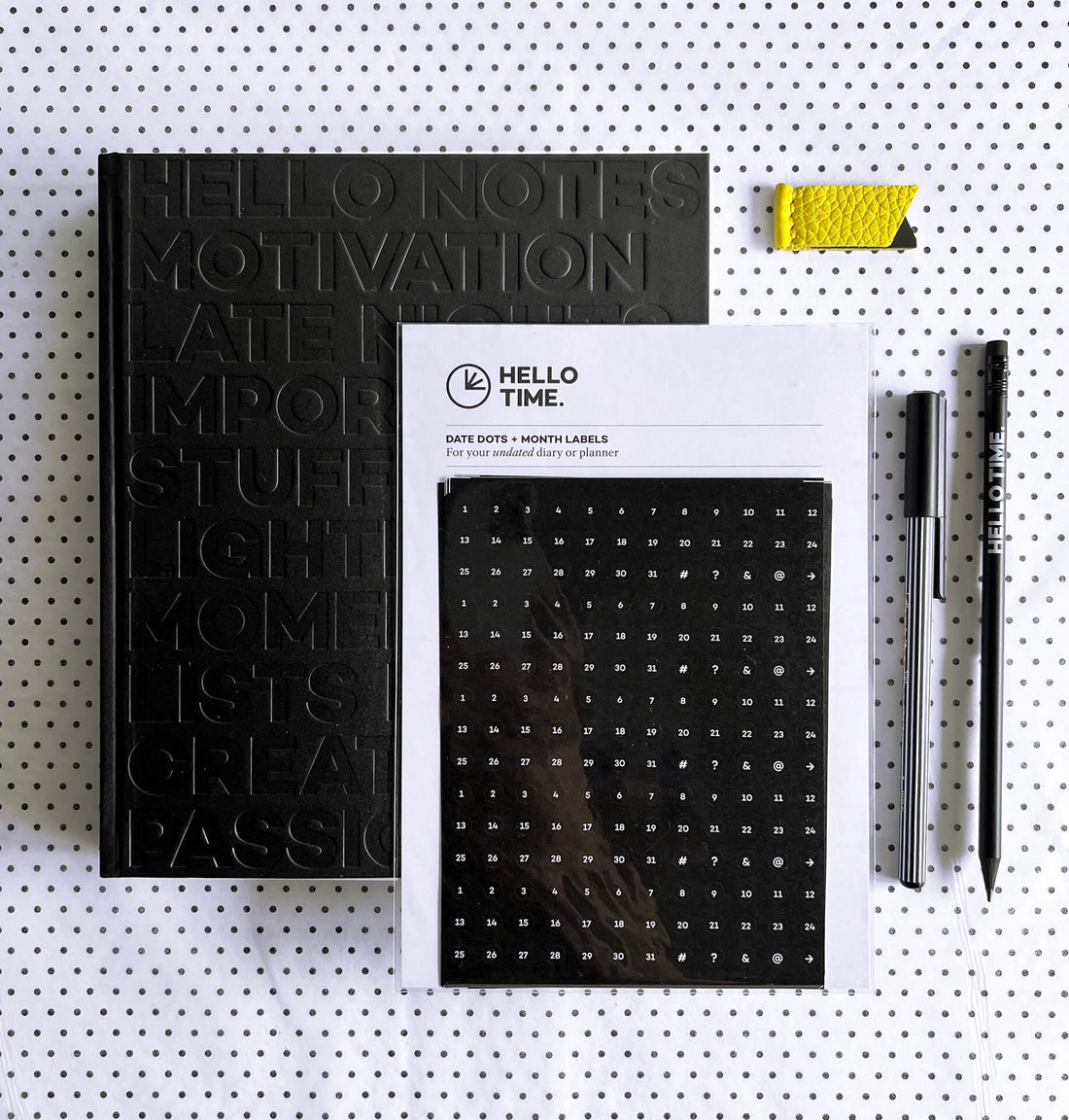HELLO TIME Life Planning Kit flatlay with black notebook, date stickers, yellow leather page marker, pencil and fineliner