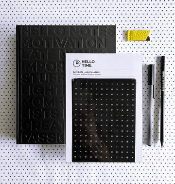 HELLO TIME Life Planning Kit flatlay with black notebook, date stickers, yellow leather page marker, pencil and fineliner