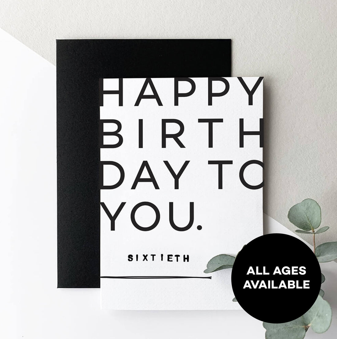 Black and white milestone birthday card reading Happy Birthday To You, Sixtieth, with black envelope.