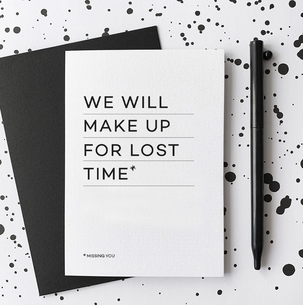 White greetings card with “We will make up for lost time” text, black envelope and pen.
