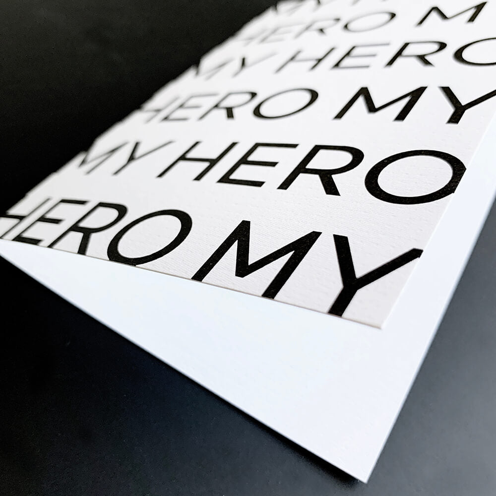 Monochrome Dad birthday greetings card with repeated My Hero text in bold black font.