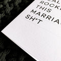 Close-up of white textured card with bold black text 
