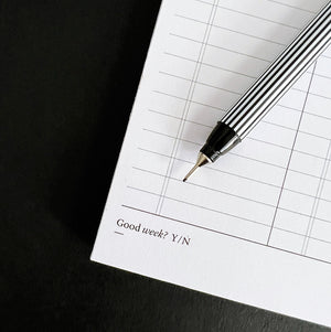 Close-up of Hello Time My Week Desk Pad with pen and “Good week? Y/N” tick box section