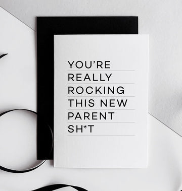 Black and white New Parents greetings card with bold typography on white card, paired with a black envelope.