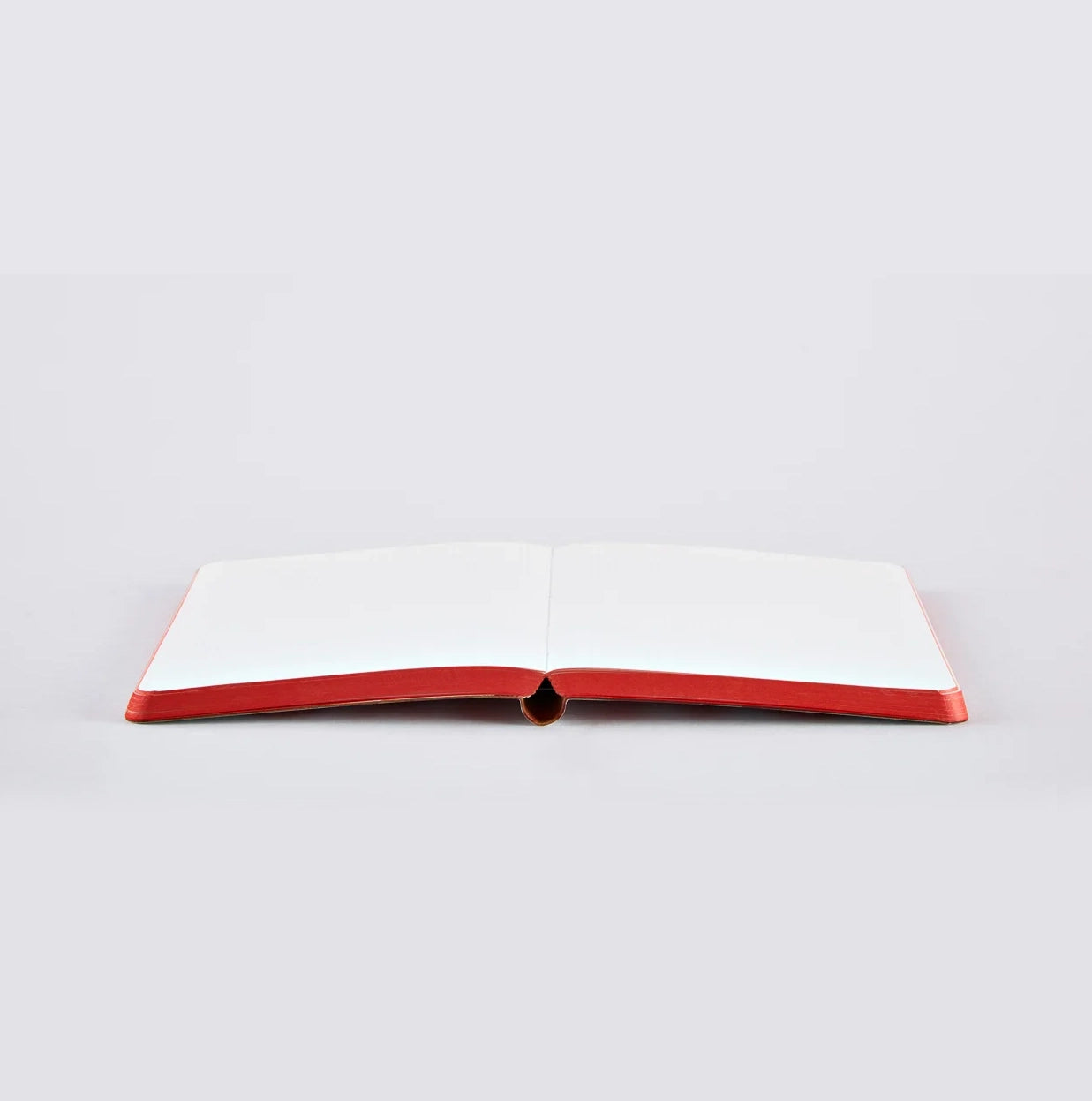 Nuuna LOVE notebook lying open flat with red-edged white pages