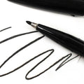 Pentel black sign pen writing black ink strokes on white paper
